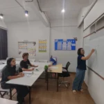 A Thai language teacher explaining a lesson at the whiteboard